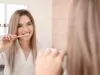 Young woman brushing teeth in bathroom