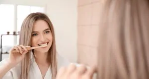 Young woman brushing teeth in bathroom